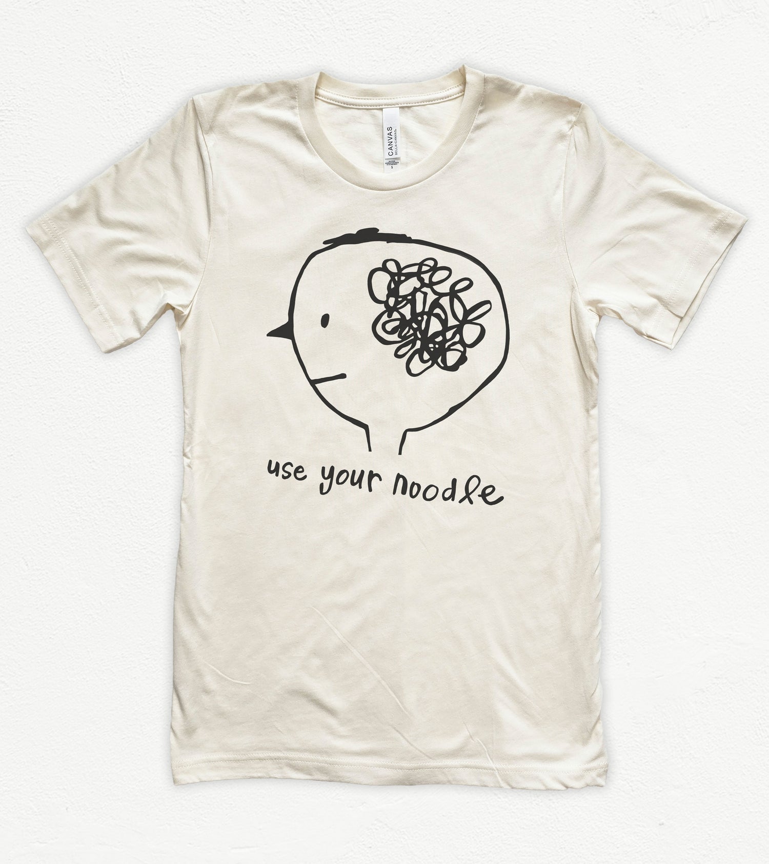 Beige t-shirt with a graphic of a brain and text 'use your noodle' on a white background